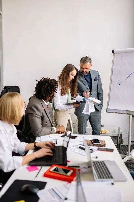 Business professionals examining analytics on a tablet in a meeting.